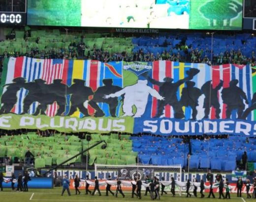 A large display in the Sounders supporters section, featuring flags from multiple nations with the text "E Pluribus Sounders"